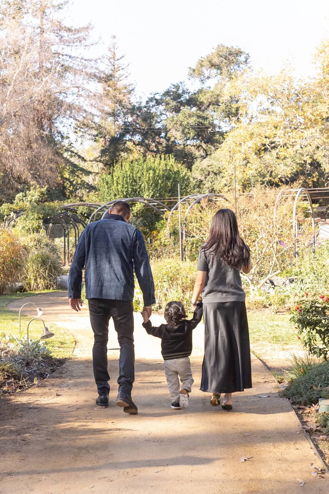 Drew, Thalia, and Ezra Nagda walking in a garden in Pasadena